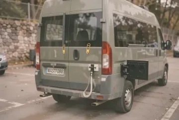 Abnehmbare Westfalia-Anhängerkupplung am Wohnmobilheck mit gelbem Sicherungspilz und 13-poliger Steckdose