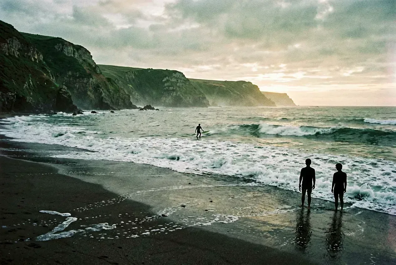 Atlantikküste bei Sagres im Sonnenaufgang mit einsamem Surfer auf dem Wasser